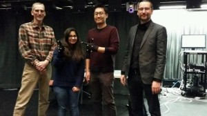 Teaching a Computer to Transform Data Into Sound. Woohun Joo(second from right) wears motion capture gloves to 'conduct' music and sound in the "Cube" at Virginia Tech. L to R, Greg Earl, Disha Sardana, Woohun Joo, Ico Bukvic