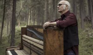 Composer Ludovico Einaudi standing behind a piano
