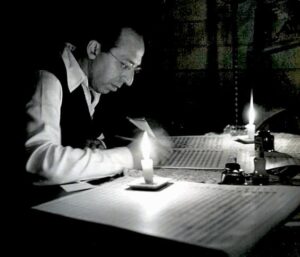 Composer Aaron Copland composing at night
