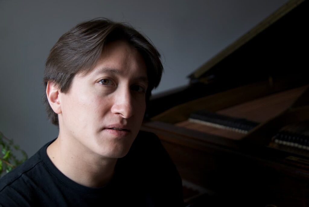 Freddy Kempf in front of a piano