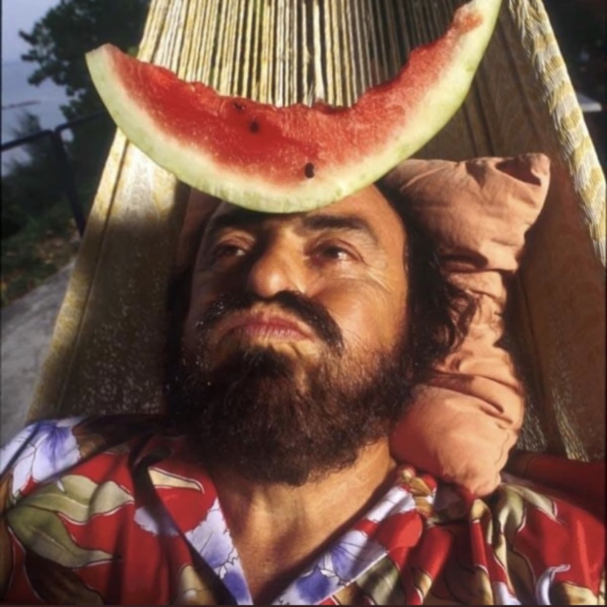 Luciano Pavarotti taking funny picture with watermelon