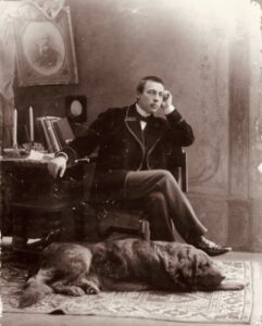 Photo of composer Rachmaninoff posing with his dog