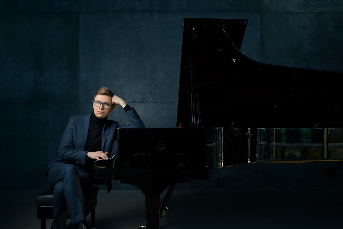Photo of Vikingur Ólafsson sitting at the grand piano