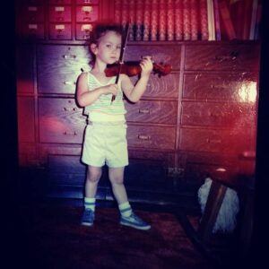 Photo of violinist Hilary Hahn playing the violin as a little girl