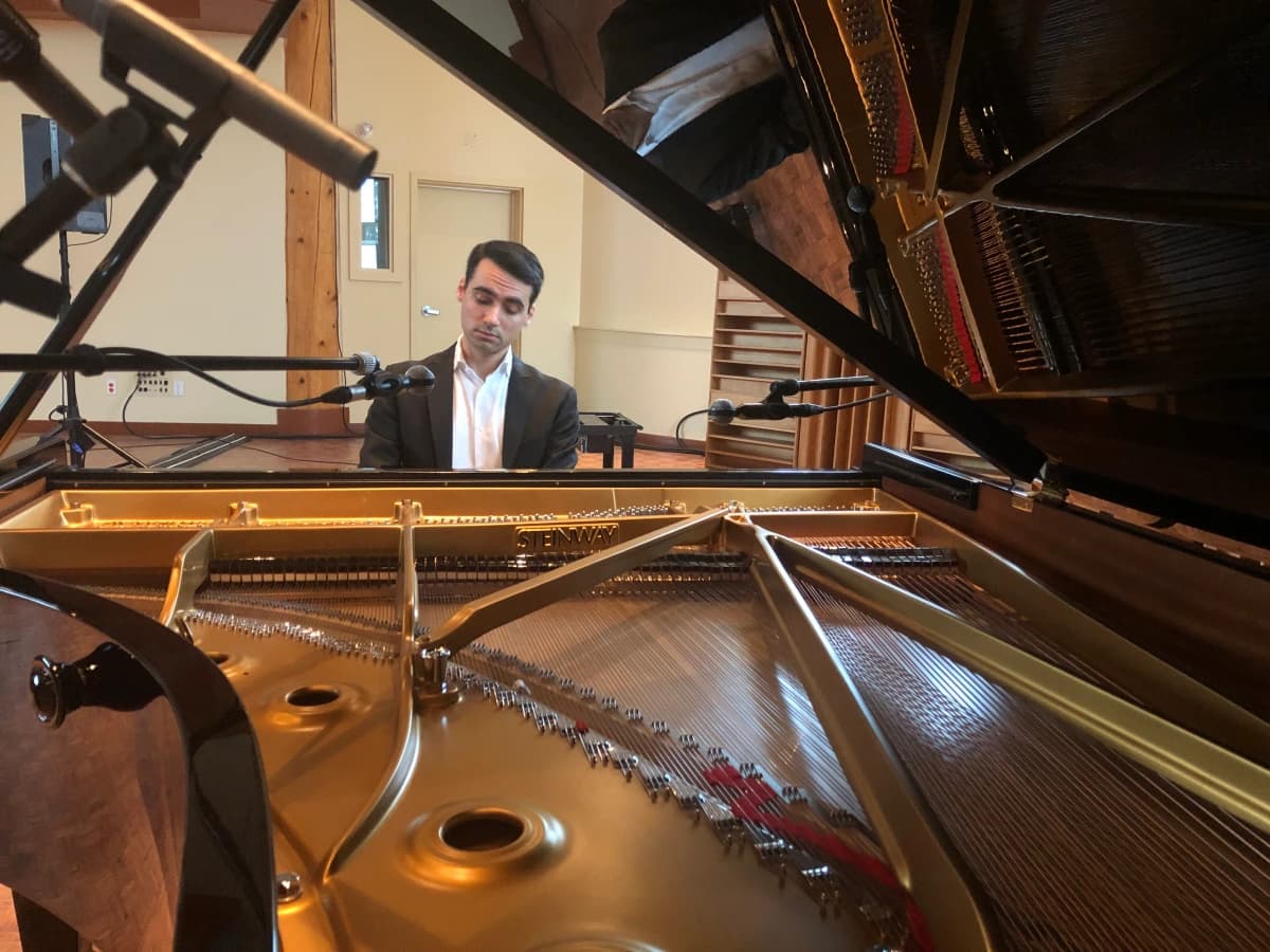 Photo of pianist Tal Walker playing a concert grand piano