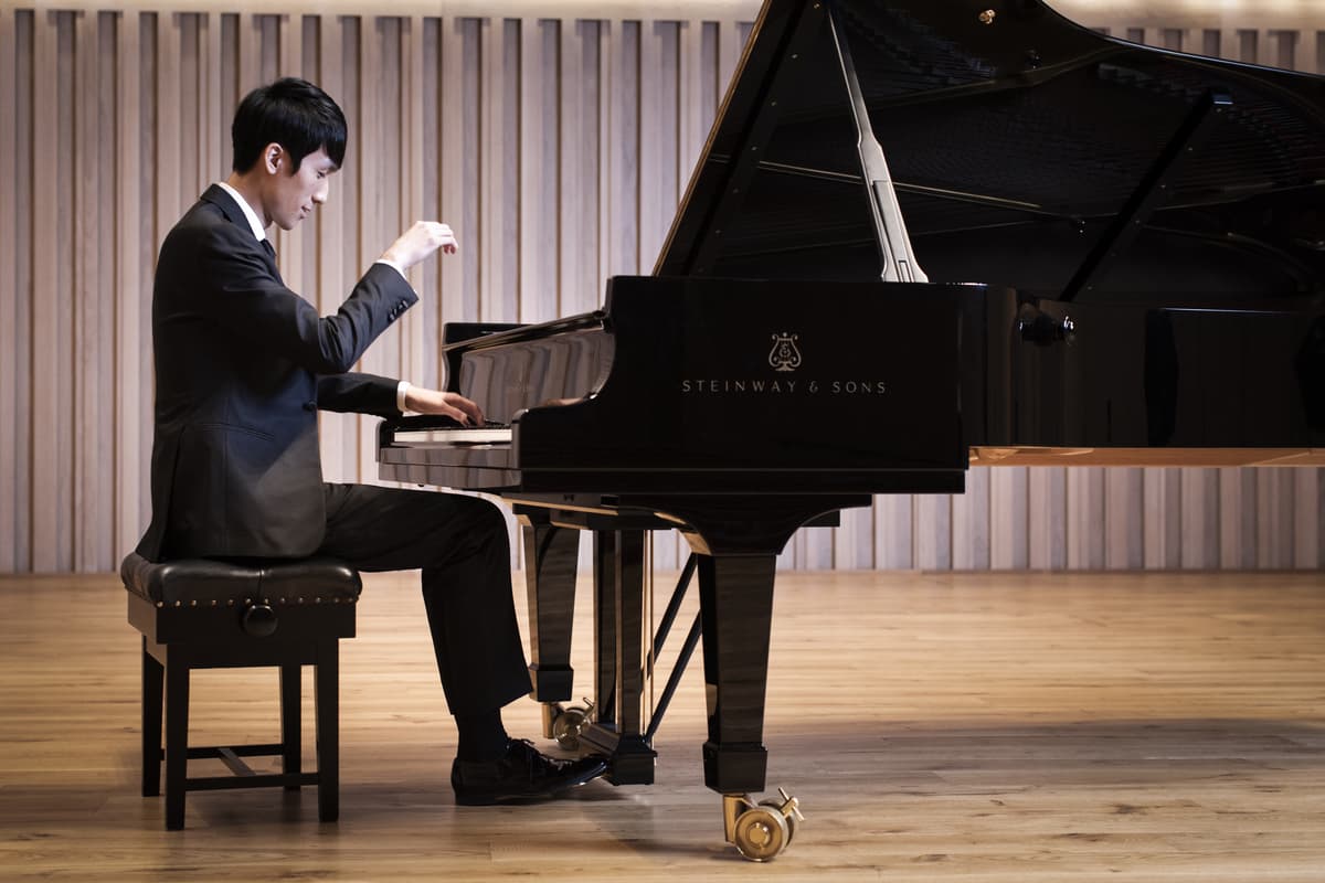 Photo of pianist Eric Lu playing a Steinway Grand