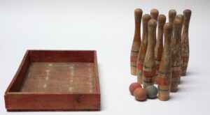 Photo of antique painted wooden skittles bowling pins with balls and box