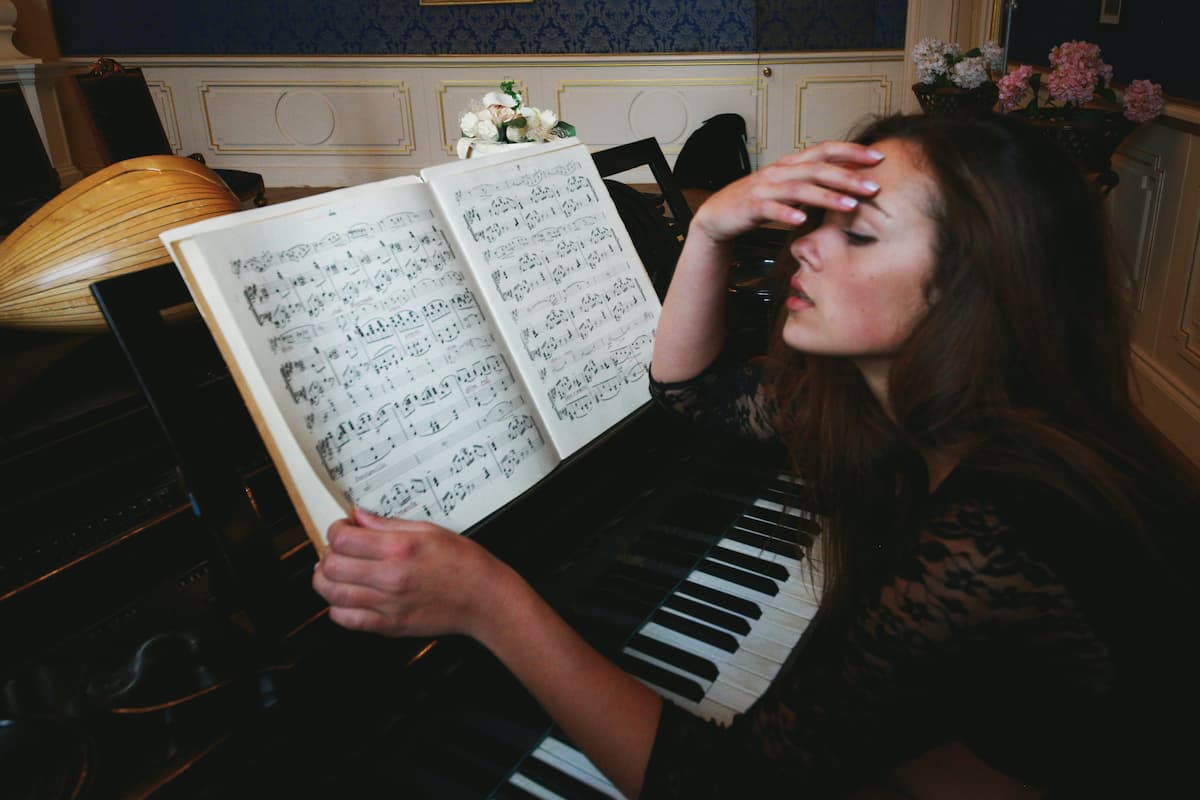 tired woman sitting by the piano