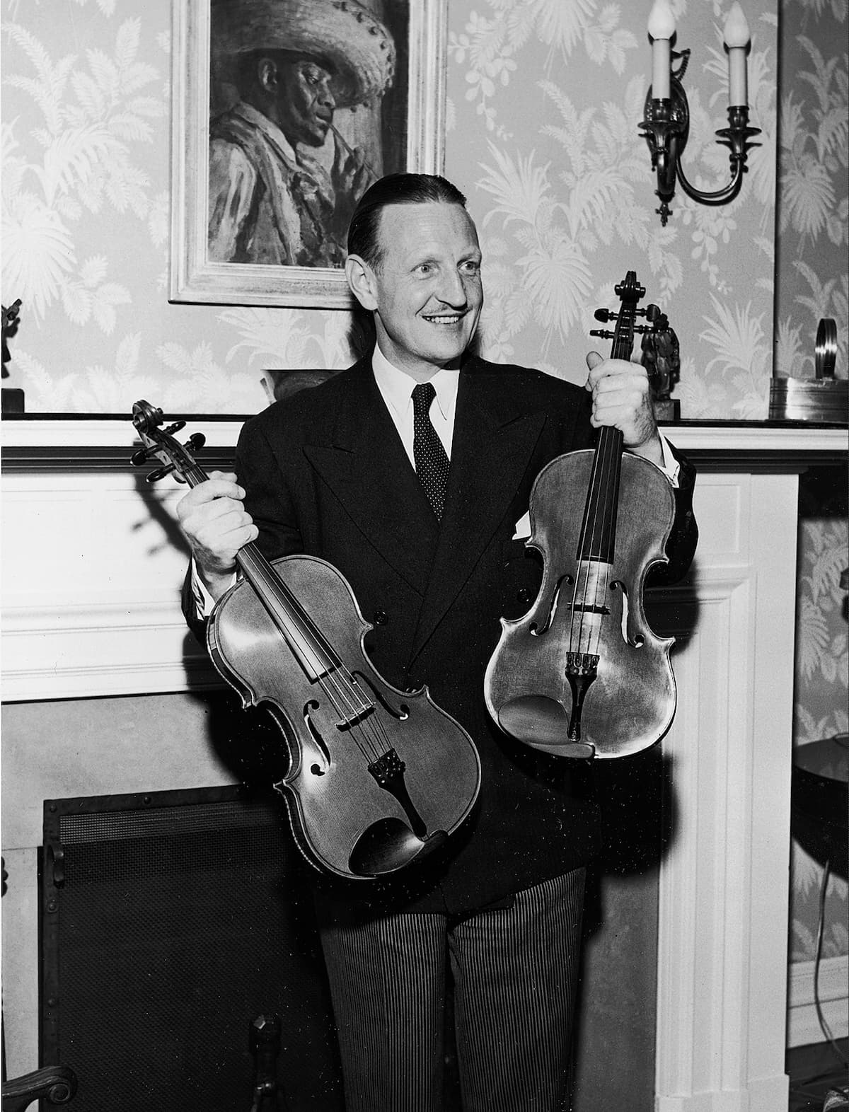 William Primrose holds two violins made for him by William Moennig Jr., 1950