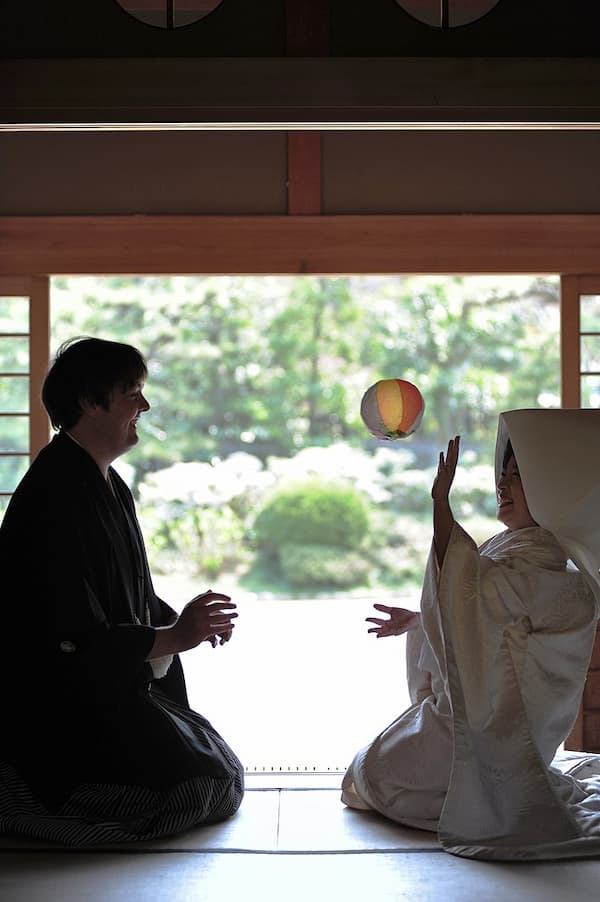 Newlyweds playing with a paper balloon (Photo by gwaar)