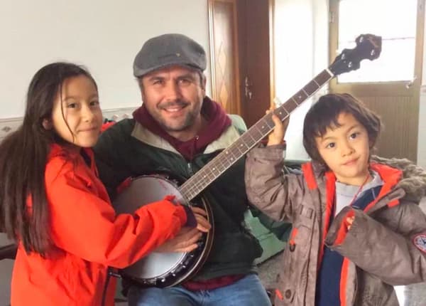 Jeremy Van Sluytman with his banjo and his daughter and son