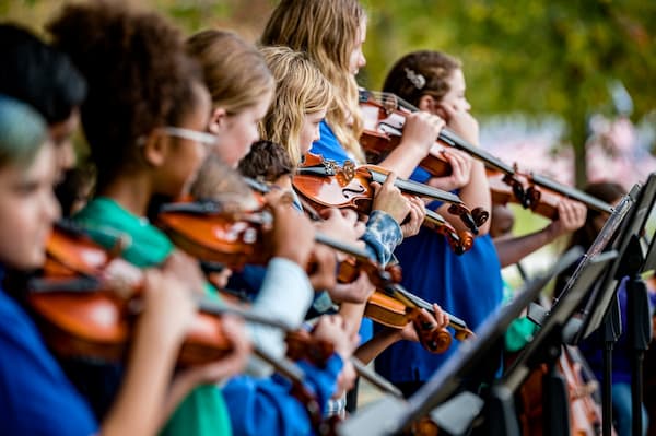 Beginning students learning violin in a group