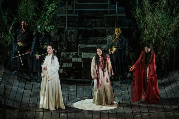 After Liu is tortured, Ping (Haris Andrianos), Pang (Yannis Kalyvas), and Pong (Andreas Karaoulis), Turandot (Lise Lindstrom), Liù (Cellia Costea), and Lo-u-Ling (Polena Kolia Petersen). 2025 (Photo by G. Antonoglou) (Greek National Opera)