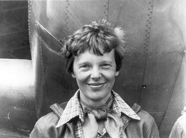 Amelia Earhart standing under nose of her Lockheed Model 10-E Electra, 1937