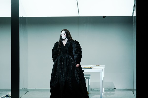 Act II: Split stage with Henry VIII (Petros Magoulas) on the left and Anne (Maria Kosovitsa) on the right. Seamstresses in their modern workrooms below, 2026 (Greek National Opera)